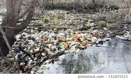 Dirty river is polluted with many plastic bottles. A lot of trash is dumped in open and freely available places at nature. Global environmental pollution problem. Concept of ecological disaster Dirty river is polluted with many plastic bottles. A lot of trash is dumped in open and freely available places at nature. Global environmental pollution problem. Concept of ecological disaster 132855521