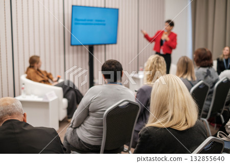 Business seminar where a speaker presents to an attentive audience in a conference room setting. Business seminar where a speaker presents to an attentive audience in a conference room setting. 132855640