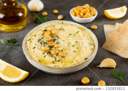 Creamy lupini bean hummus with olive oil, garlic, lemon and herbs in a ceramic bowl. Healthy vegan dip. Close-up. Creamy lupini bean hummus with olive oil, garlic, lemon and herbs in a ceramic bowl. Healthy vegan dip. Close-up. 132855811