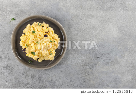 Scrambled eggs with microgreens on gray background. Breakfast concept. Top view. Copy space. 132855813