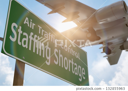 Air Traffic Control Staffing Shortage Green Road Sign with Airplane Above. 132855963