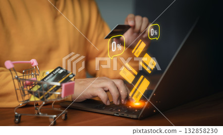 Online shopping with credit card and 0% interest promotion. Person uses laptop for e-commerce transaction, symbolizing digital payment, installment plan, consumer finance, online retail convenience. 132858230