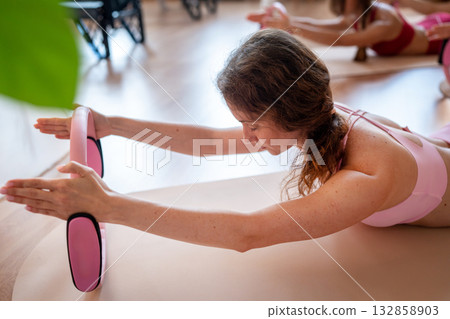 Exercises with pilates ring. Woman doing aerobics workout at pilates studio with panoramic windows. 132858903