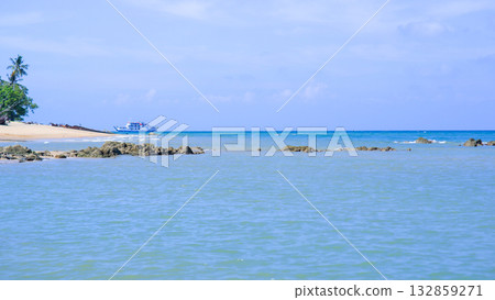 View of a Distant Ferry Ship Sailing on the Horizon of a Calm Blue Tropical Sea View of a Distant Ferry Ship Sailing on the Horizon of a Calm Blue Tropical Sea 132859271