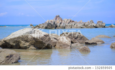 Large Boulders and Rocks in the Shallow Tropical Water with Dramatic Outcrop in Background Large Boulders and Rocks in the Shallow Tropical Water with Dramatic Outcrop in Background 132859505
