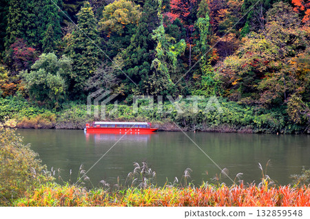 Autumn leaves on the Mogami River, Mogami River Basho Line boat ride, moored tourist boat Autumn leaves on the Mogami River, Mogami River Basho Line boat ride, moored tourist boat 132859548