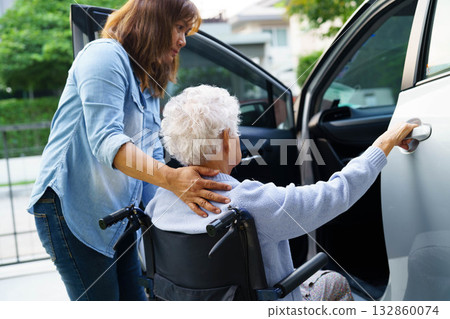 Caregiver help Asian elderly woman disability patient use wheelchair to get in car. Caregiver help Asian elderly woman disability patient use wheelchair to get in car. 132860074