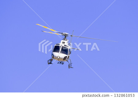 A tourist helicopter in flight around a sporting event 132861053