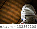 Detail composition of wooden floor and white sneakers 132862108