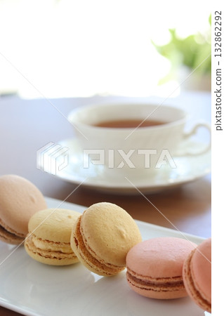 白色盤子上放著馬卡龍和茶。 白色盤子上放著馬卡龍和茶。 132862292
