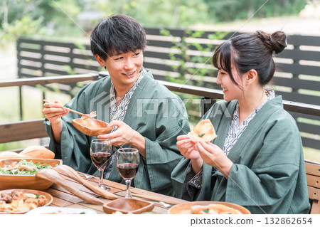 Young Asian couple at a Japanese inn or hot spring inn having a meal on the balcony or wooden deck (travel and travel) 132862654