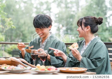 日本旅館或溫泉旅館的年輕亞洲夫婦在陽台或木甲板上用餐（旅行和旅行） 132862656