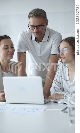 Business people collaborating and analyzing data on a laptop during an office meeting 132862723