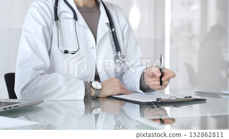 Medical professional writing prescription on clipboard, consulting in office, offering healthcare and treatment. Medicine and health care 132862811