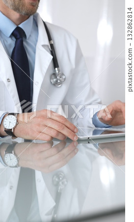 Doctor using tablet computer, providing healthcare consultation, digital medical technology, professional man in lab coat. Medicine and health care Doctor using tablet computer, providing healthcare consultation, digital medical technology, professional man in lab coat. Medicine and health care 132862814