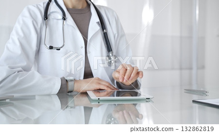 Doctor using digital tablet for remote medical consultation, providing modern healthcare services, telehealth concept. Medicine and health care Doctor using digital tablet for remote medical consultation, providing modern healthcare services, telehealth concept. Medicine and health care 132862819