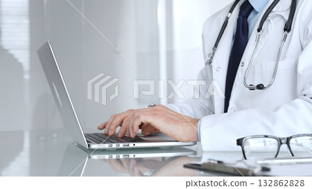 Doctor or healthcare professional using a laptop computer, focusing on telemedicine, digital health records, or medical research. Medicine, healthcare and science concept 132862828
