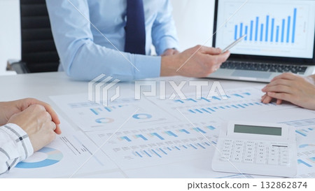 Businessman professional pointing laptop screen showing bar graphs, calculator on table while team collaborates on financial analysis and planning. Business people concept Businessman professional pointing laptop screen showing bar graphs, calculator on table while team collaborates on financial analysis and planning. Business people concept 132862874