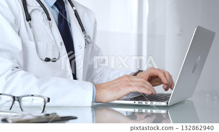 Doctor or healthcare professional using a laptop computer, focusing on telemedicine, digital health records, or medical research. Medicine, healthcare and science concept 132862940