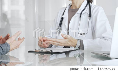 Doctor discussing health status with patient during medical consultation, offering advice in clinic. Medicine and health care 132862955