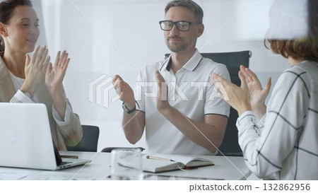 Professional team applauding, celebrating collaborative success and recognizing outstanding performance during corporate meeting, expressing shared workplace achievement. Business people concept 132862956