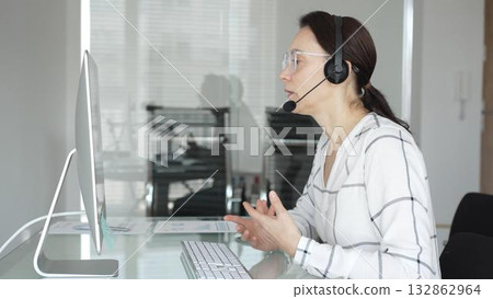 Woman working in call center, providing customer support through headset, communicating in virtual office meeting. Business people concept 132862964