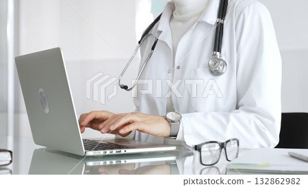 Healthcare professional working on laptop, providing digital medicine consultation and tele health service. Medicine, healthcare and science concept Healthcare professional working on laptop, providing digital medicine consultation and tele health service. Medicine, healthcare and science concept 132862982