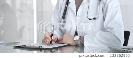 Doctor writing prescription or medical record, providing patient care and healthcare services in clinic. Medicine and health care 132862993