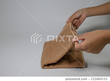 特寫鏡頭:雙手正在折疊棕色毛巾 特寫鏡頭:雙手正在折疊棕色毛巾 132864133