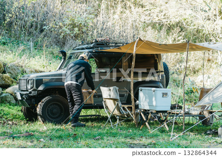 秋冬季節，男露營者在露營地搭帳篷 132864344