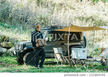 Male camper setting up a tent at a campsite in autumn and winter 132864345