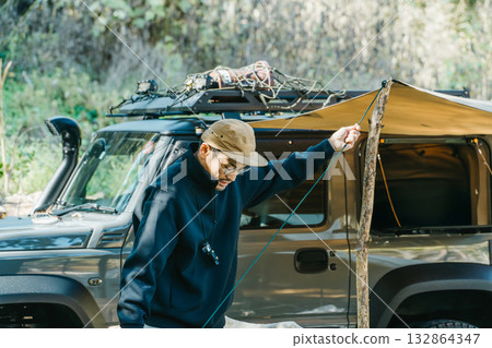 秋冬季節，男露營者在露營地搭帳篷 132864347