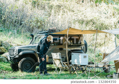 Male camper setting up a tent at a campsite in autumn and winter 132864350