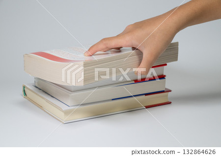 從書堆裡拿起一本書。 132864626