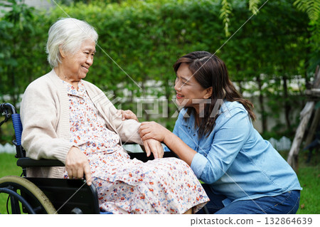 Caregiver help Asian elderly woman disability patient sitting on wheelchair in park, medical. Caregiver help Asian elderly woman disability patient sitting on wheelchair in park, medical. 132864639