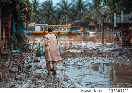 barefoot woman walking flooded city, buildings under water and mud, village underwater after heavy tropical rain and typhoon, consequences with dirt on street, Hoi An, Vietnam barefoot woman walking flooded city, buildings under water and mud, village underwater after heavy tropical rain and typhoon, consequences with dirt on street, Hoi An, Vietnam 132865925