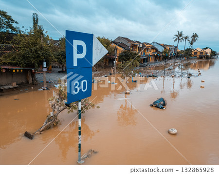 flooded city or town with buildings submerged in overflow water and mud, village underwater after heavy tropical rain and typhoon, consequences with dirt on the street 132865928