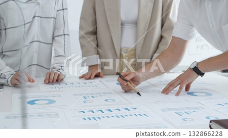 Business team working on financial charts and graphs, pointing at statistics and discussing business project data in modern office. Business people concept Business team working on financial charts and graphs, pointing at statistics and discussing business project data in modern office. Business people concept 132866228