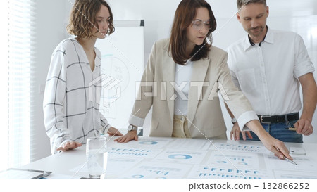 Professional team reviewing financial data, collaborating on working documents, demonstrating team achievements and positive dynamics in the workplace. Business people concept Professional team reviewing financial data, collaborating on working documents, demonstrating team achievements and positive dynamics in the workplace. Business people concept 132866252