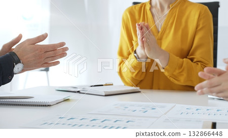 Business colleagues clapping hands after successful presentation or good news during a corporate meeting, celebrating achievement and success in office 132866448