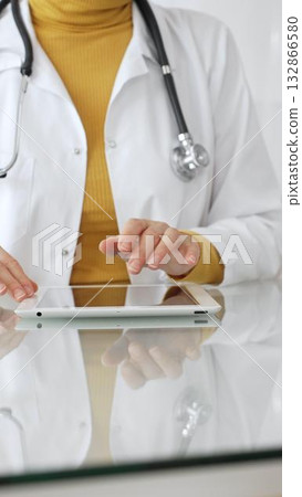 Doctor using tablet computer for digital health data, patient records, and medical application in clinic. Medicine, healthcare and science concept 132866580