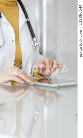 Doctor using tablet computer for digital health data, patient records, and medical application in clinic. Medicine, healthcare and science concept Doctor using tablet computer for digital health data, patient records, and medical application in clinic. Medicine, healthcare and science concept 132866644