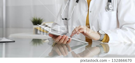 Female doctor using digital tablet, providing modern healthcare and medical technology consultation. Medicine, healthcare and science concept Female doctor using digital tablet, providing modern healthcare and medical technology consultation. Medicine, healthcare and science concept 132866670