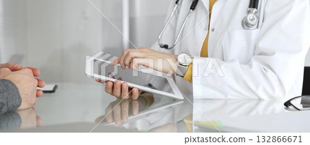 Doctor consulting patient using digital tablet, explaining medical information during modern healthcare appointment. Medicine, healthcare and science concept Doctor consulting patient using digital tablet, explaining medical information during modern healthcare appointment. Medicine, healthcare and science concept 132866671