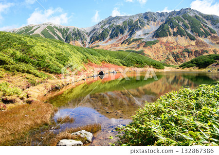 富山縣室堂平市立山黑部阿爾卑斯山脈路線的綠池倒影和立山山脈的壯麗秋景 132867386