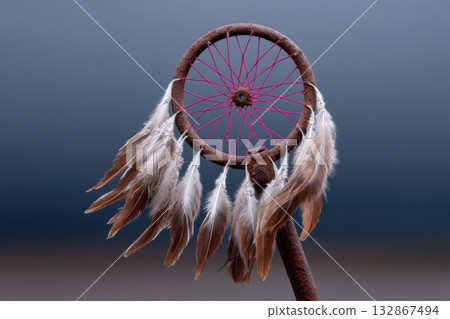 Bike wheel transformed into a colorful dreamcatcher with feathers on a soft background Bike wheel transformed into a colorful dreamcatcher with feathers on a soft background 132867494