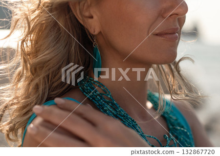 Woman beach summer, serene profile of a blonde woman wearing turquoise jewelry on a sunny outdoor day 132867720