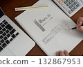 A close-up of an architect performing energy-saving calculations for a house. 132867953
