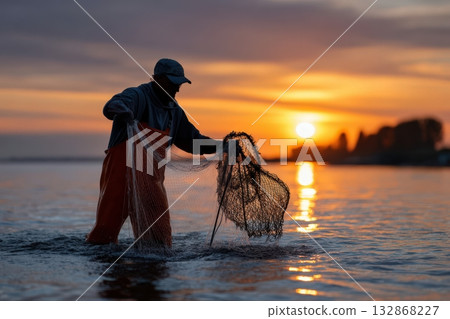 Fisherman pulls net full of fish at sunrise on tranquil water Fisherman pulls net full of fish at sunrise on tranquil water 132868227