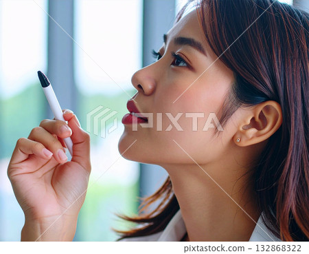 Thinking young woman holding a pen 132868322